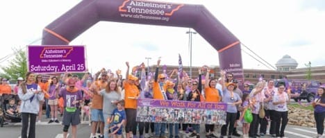 Photo of a large group of people posing under the Alzheimers Tennessee arch